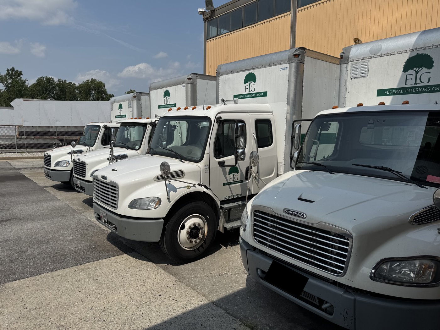 Federal Interiors Group fleet of Freightliner box trucks staged outside the warehouse